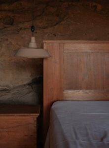 Wooden headboard and bedside table with lamp.